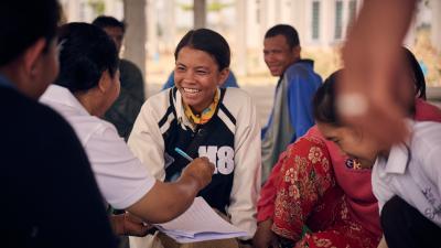 young women smiles amongst group of workers